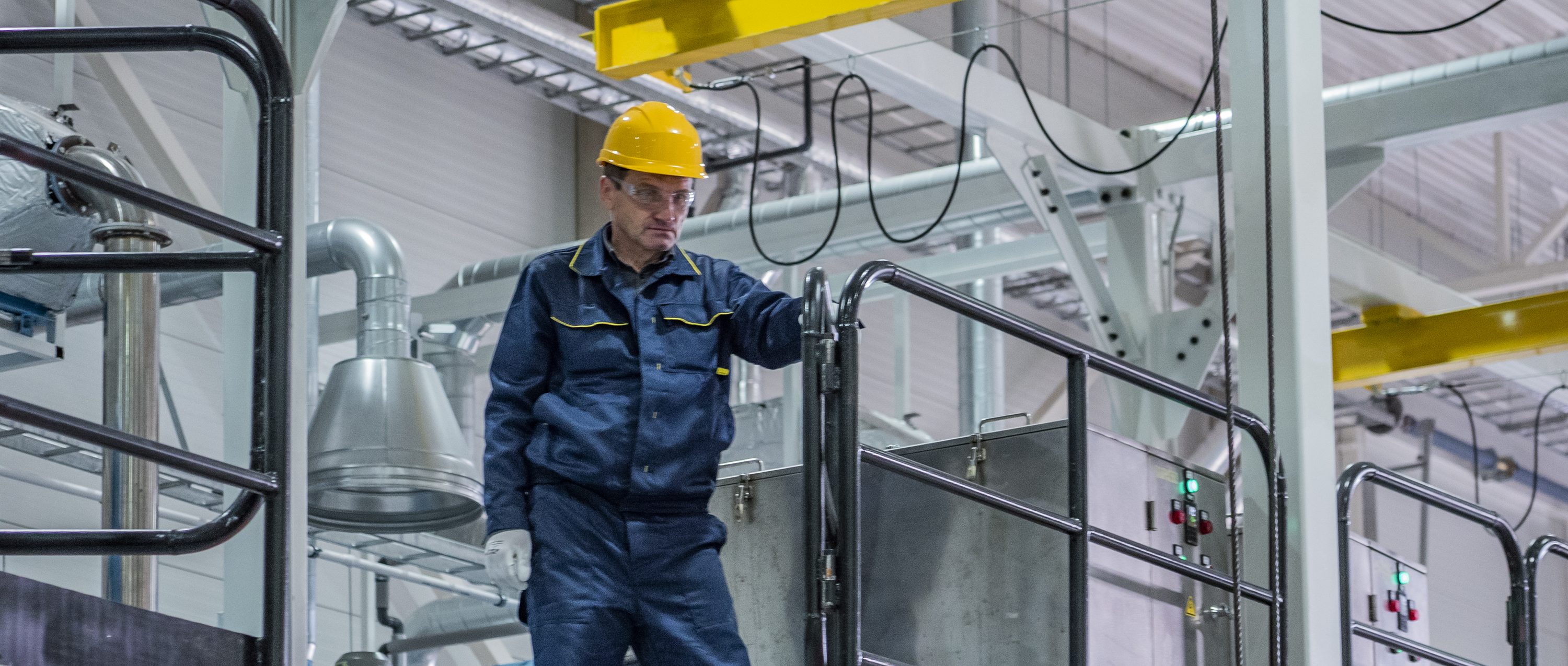 An operator on the upper deck of the plant, checking the line